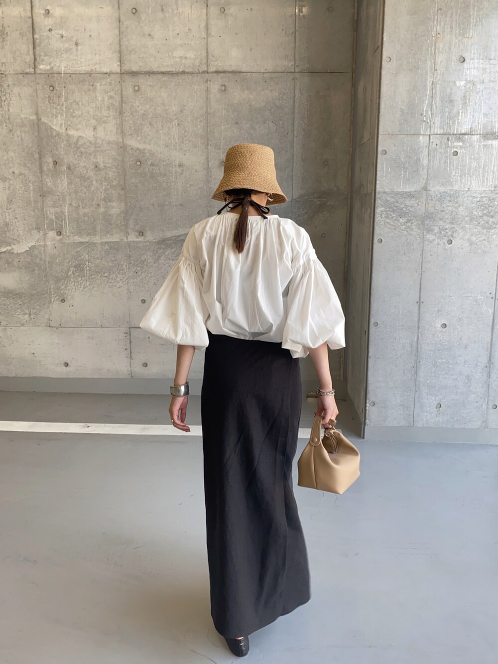 ブラック系のワンピース、ホワイト系のシャツ/ブラウス、ベージュ系のハンドバッグを着用したレディースの秋コーディネートの2枚目の写真