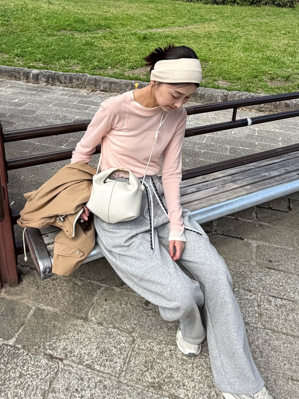 ピンク系のTシャツ/カットソー、グレー系のスウェットパンツ、ホワイト系のショルダーバッグを着用したレディースの春コーディネートの3枚目の写真