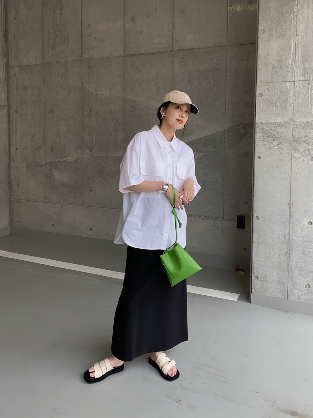 ホワイト系のシャツ/ブラウス、グリーン系のハンドバッグ、ホワイト系のサンダルを着用したレディースの夏コーディネートの2枚目の写真