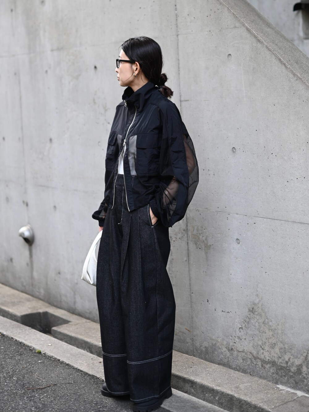 ブラック系のブルゾン、ブラック系のデニムパンツ、ホワイト系のショルダーバッグを着用したレディースの秋コーディネートの5枚目の写真