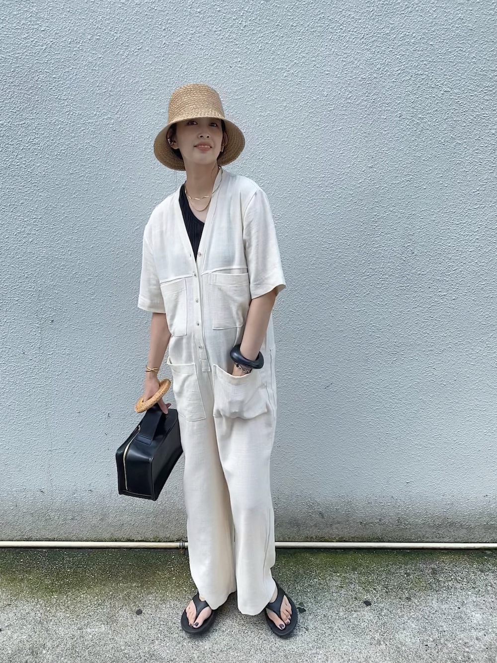 ホワイト系のサロペット/オーバーオール、ブラック系のサンダル、ベージュ系のハットを着用したレディースの夏コーディネートの3枚目の写真
