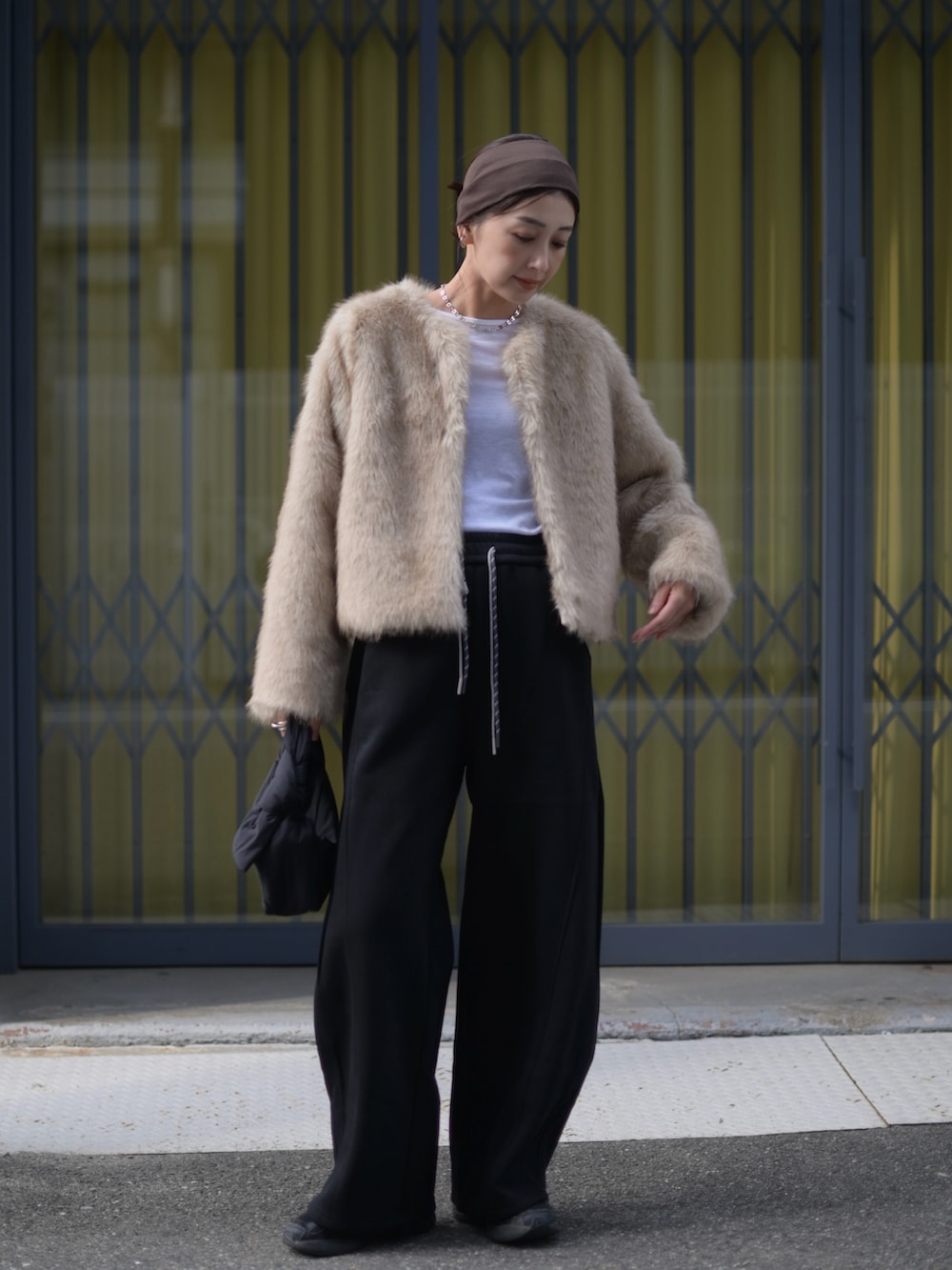 ベージュ系のその他アウター、ブラック系のスウェットパンツ、ブラック系のスニーカーを着用したレディースの冬コーディネートの5枚目の写真