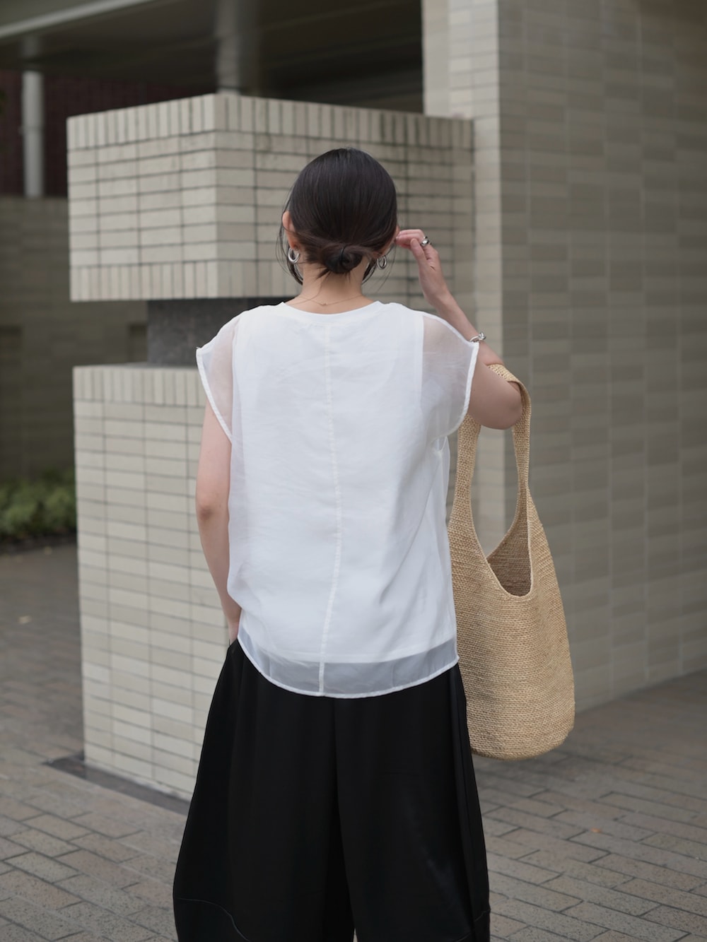 ブラック系のその他パンツ、ホワイト系のTシャツ/カットソー、ベージュ系のかごバッグを着用したレディースの夏コーディネートの2枚目の写真