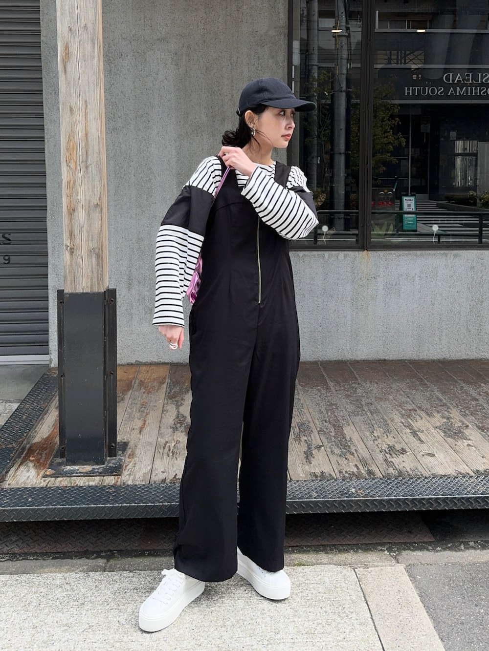 ブラック系のサロペット/オーバーオール、ホワイト系のスニーカー、ブラック系のTシャツ/カットソーを着用したレディースの春コーディネートの2枚目の写真