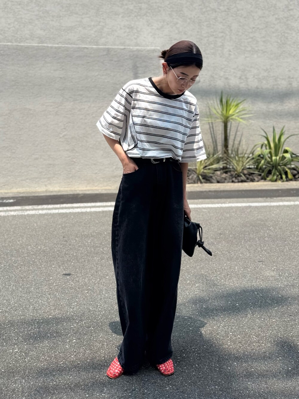 ブラック系のデニムパンツ、ホワイト系のTシャツ/カットソー、ブラック系のヘアバンドを着用したレディースの夏コーディネートの2枚目の写真