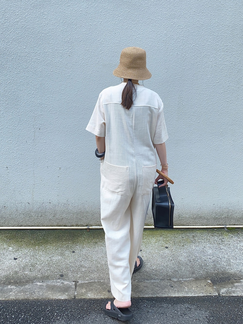 ホワイト系のサロペット/オーバーオール、ブラック系のサンダル、ベージュ系のハットを着用したレディースの夏コーディネートの2枚目の写真