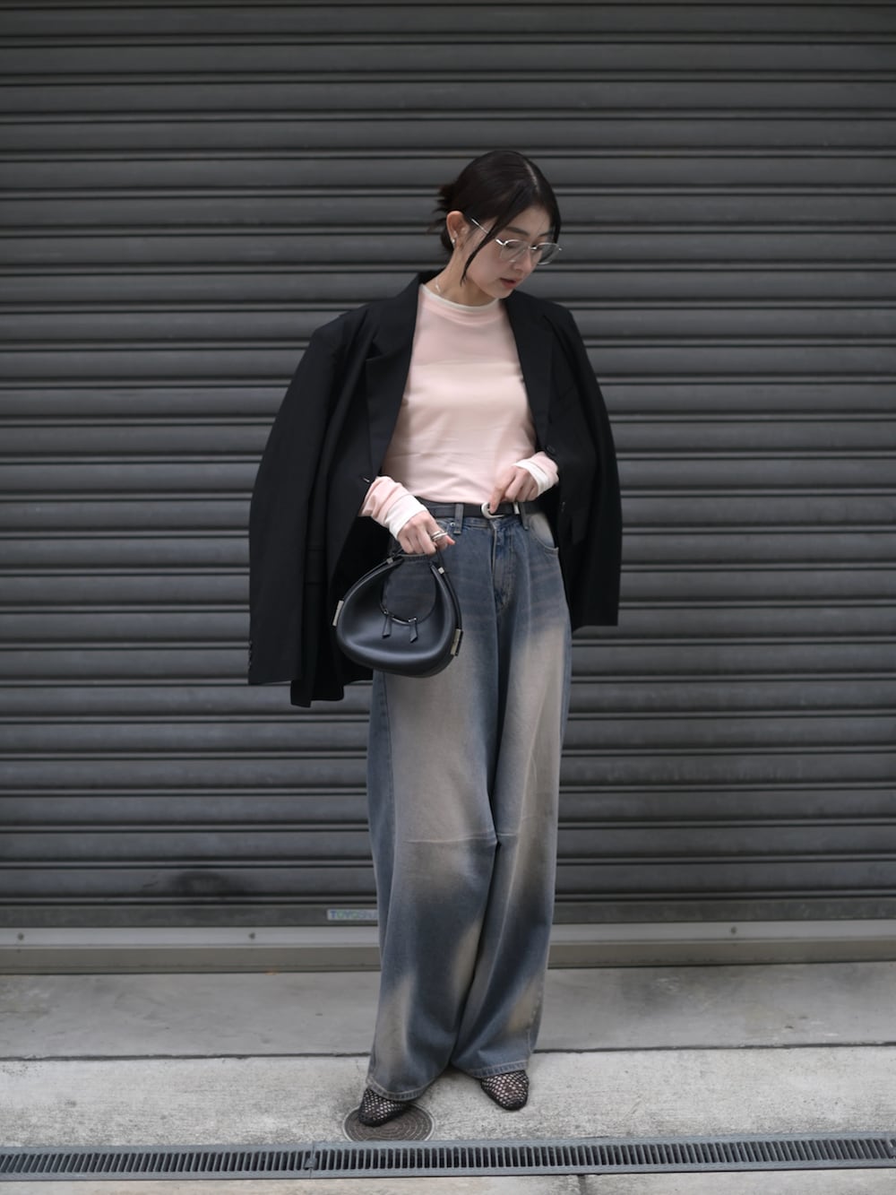 ピンク系のTシャツ/カットソー、ブラック系のハンドバッグ、ブルー系のデニムパンツを着用したレディースの春コーディネートの5枚目の写真