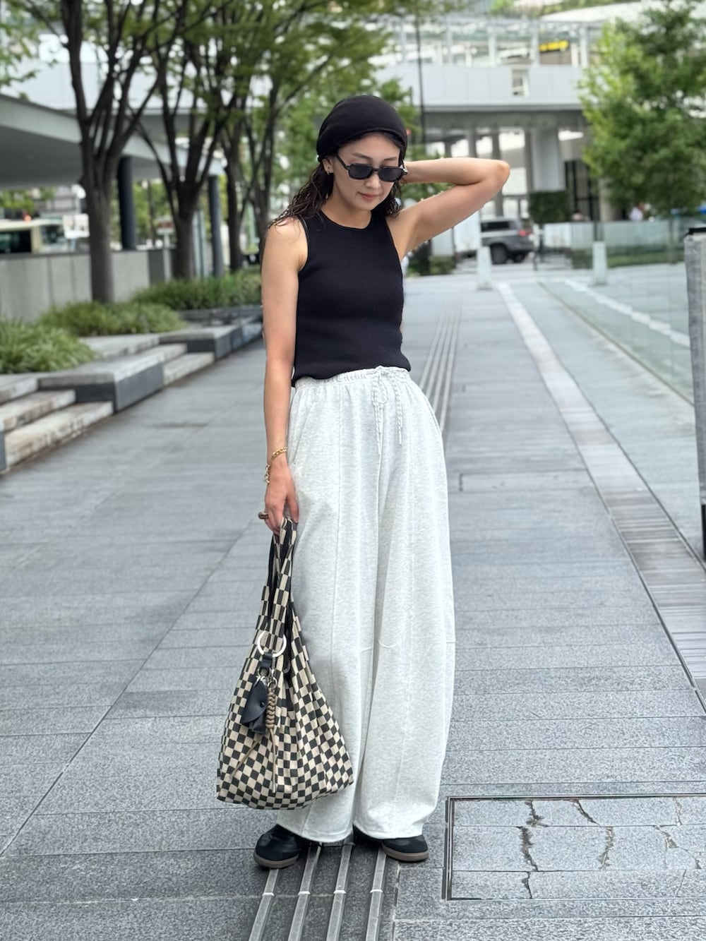 グレー系のスウェットパンツ、ブラック系のスニーカー、ブラック系のサングラスを着用したレディースの夏コーディネートの2枚目の写真