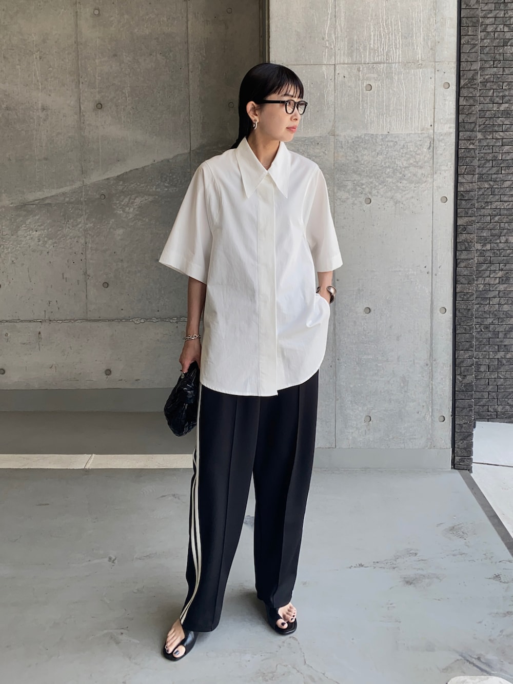 ホワイト系のシャツ/ブラウス、ブラック系のスウェットパンツ、ブラック系のメガネを着用したレディースの夏コーディネートの2枚目の写真