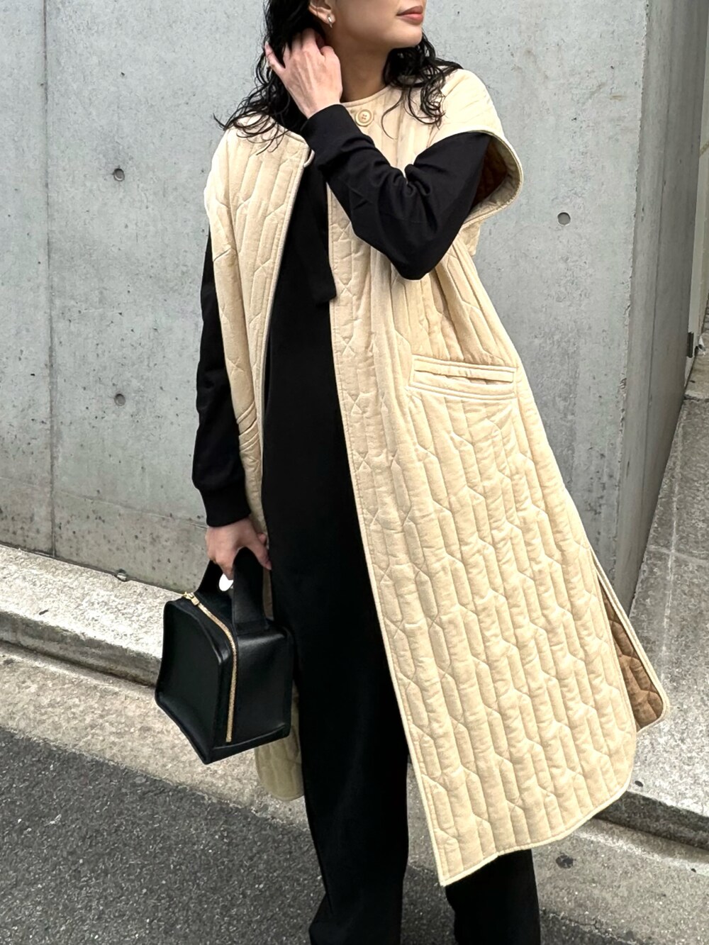 ブラック系のサロペット/オーバーオール、ブラック系のブーツ、ベージュ系のミリタリージャケットを着用したレディースの冬コーディネートの2枚目の写真