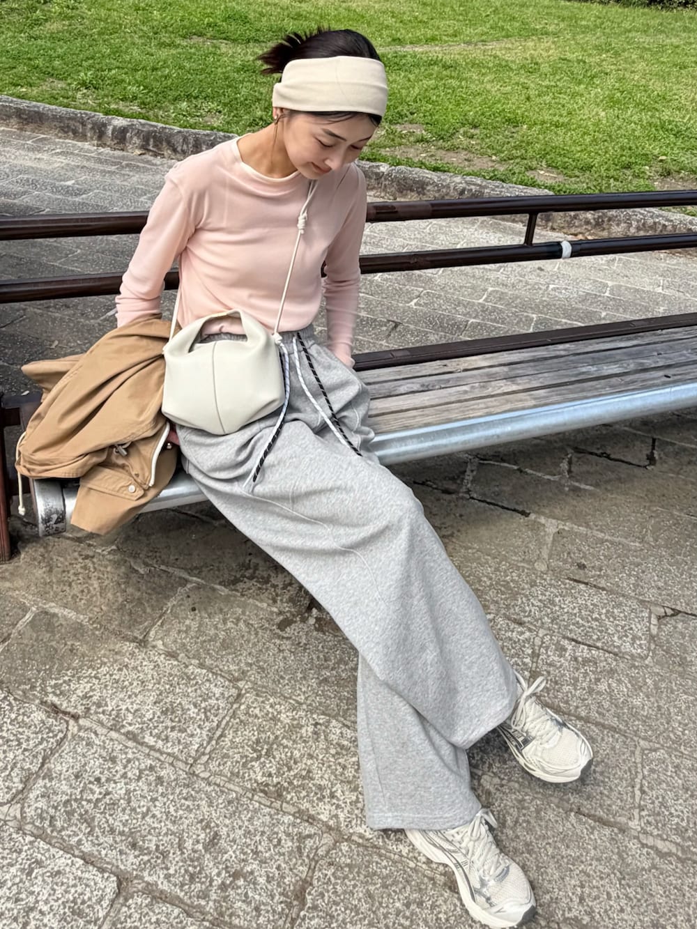 ピンク系のTシャツ/カットソー、グレー系のスウェットパンツ、ホワイト系のショルダーバッグを着用したレディースの春コーディネートの2枚目の写真