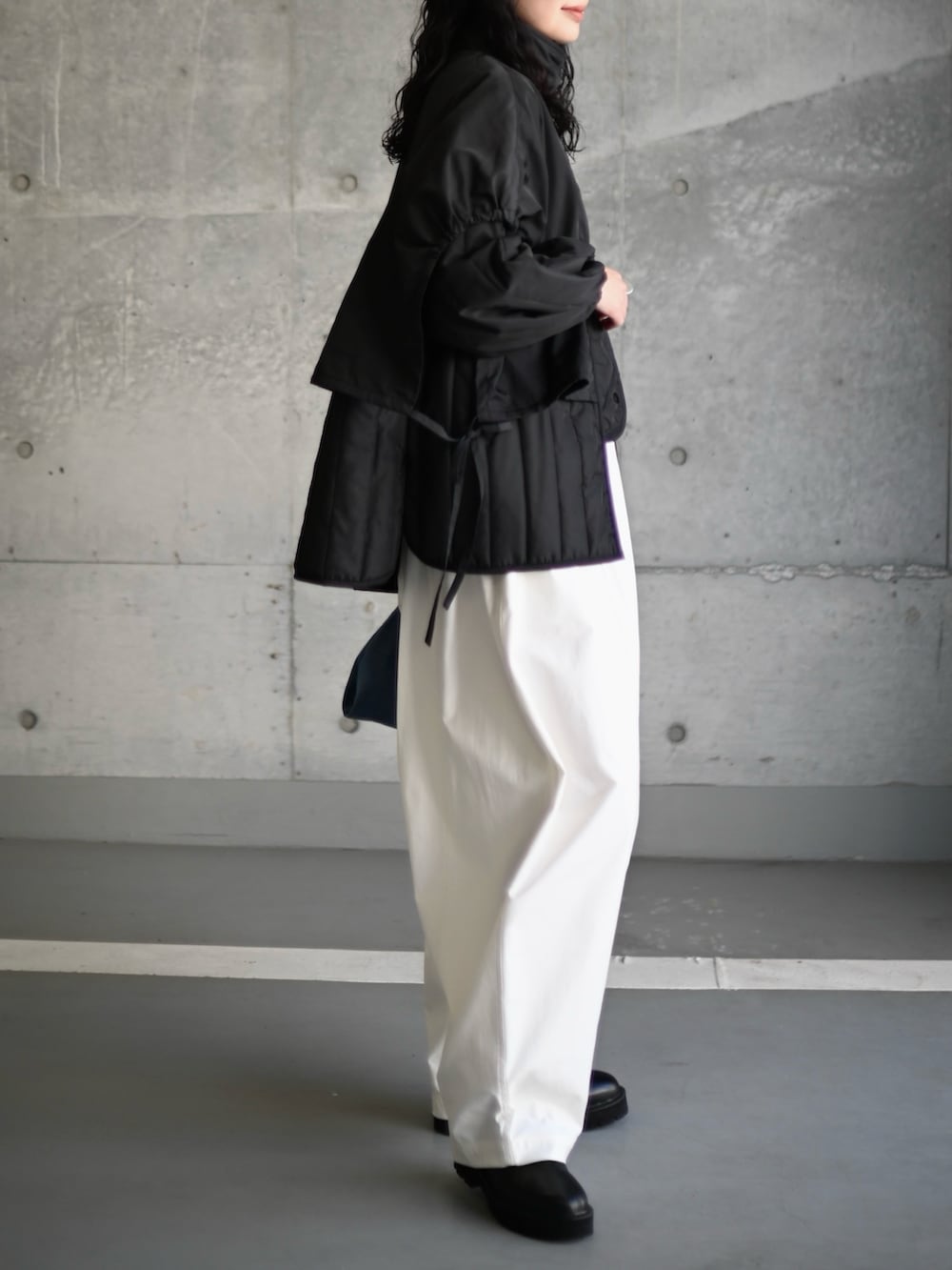 ブラック系のダウンジャケット/コート、ホワイト系のその他パンツ、ブラック系のブーツを着用したレディースの秋コーディネートの2枚目の写真