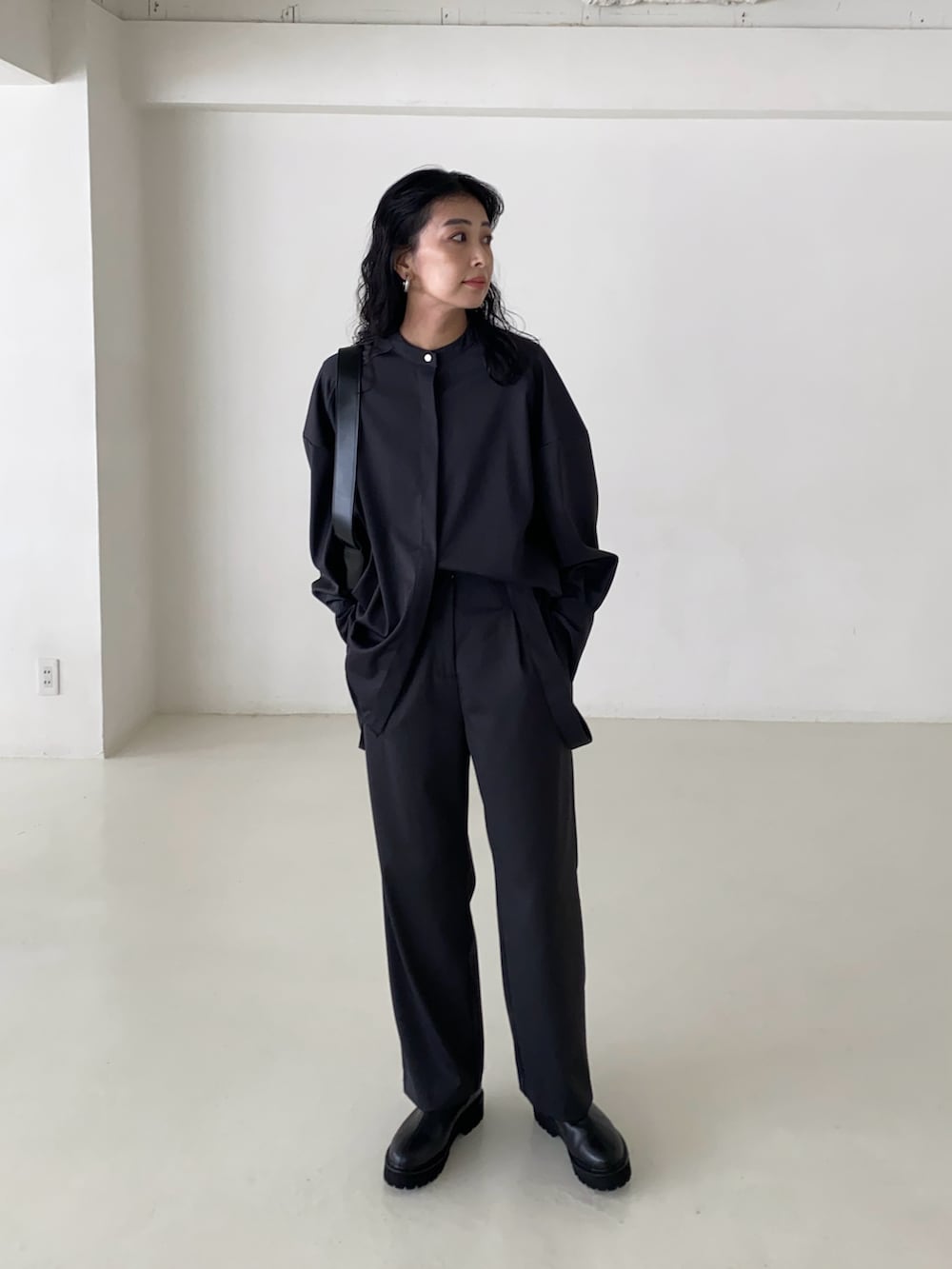 グレー系のシャツ/ブラウス、グレー系のスラックス、ブラック系のブーツを着用したレディースの春コーディネートの3枚目の写真