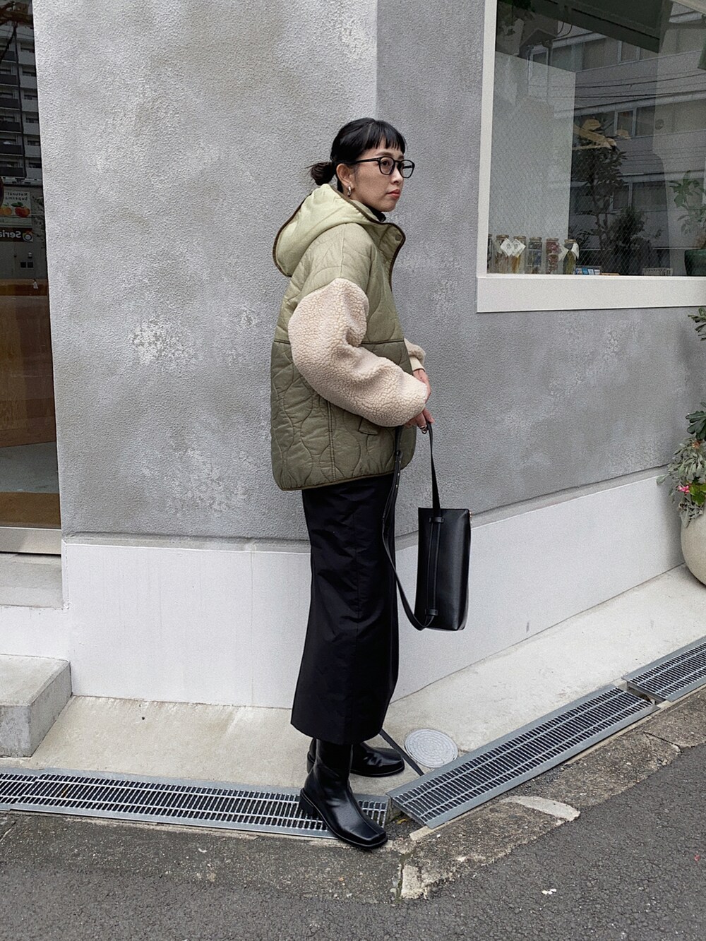 グリーン系のダウンジャケット/コート、ブラック系のスカートを着用したレディースの秋コーディネートの2枚目の写真