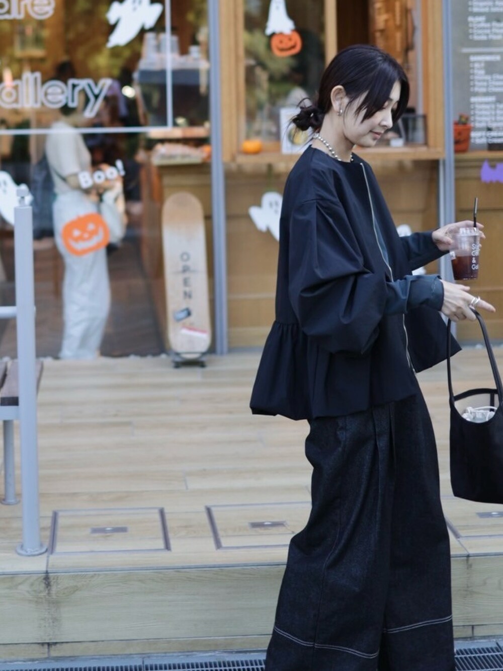 ブラック系のブルゾン、グレー系のTシャツ/カットソー、ブラック系のデニムパンツを着用したレディースの秋コーディネートの3枚目の写真