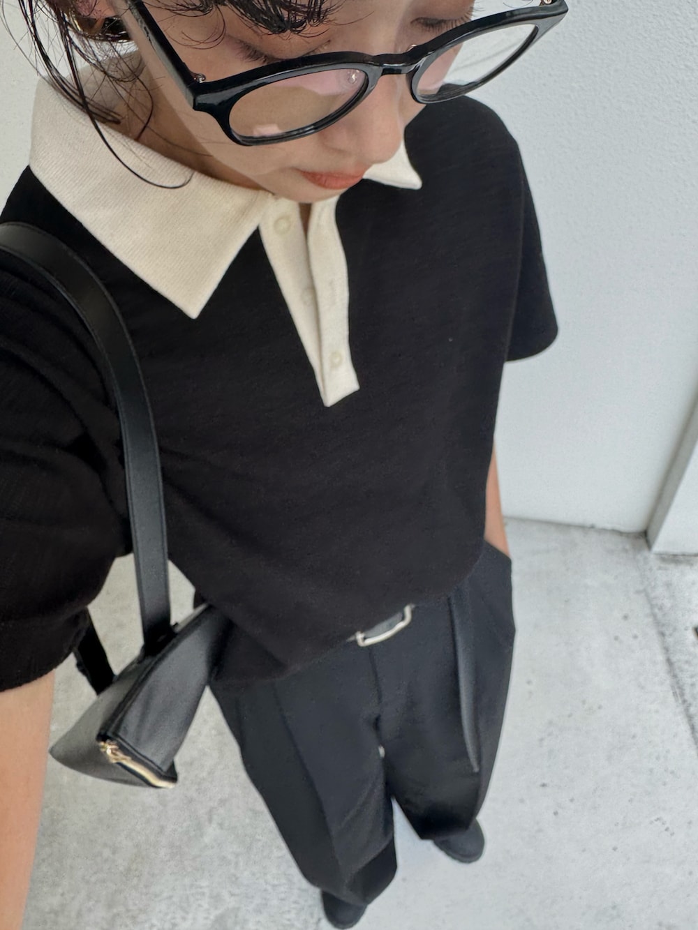 ブラック系のTシャツ/カットソー、ブラック系のスラックス、ブラック系のショルダーバッグを着用したレディースの夏コーディネートの3枚目の写真