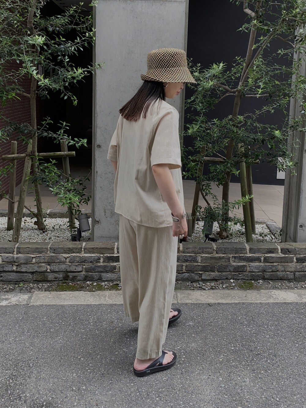 ブラック系のサンダル、ブラック系のハットを着用したレディースの夏コーディネートの2枚目の写真