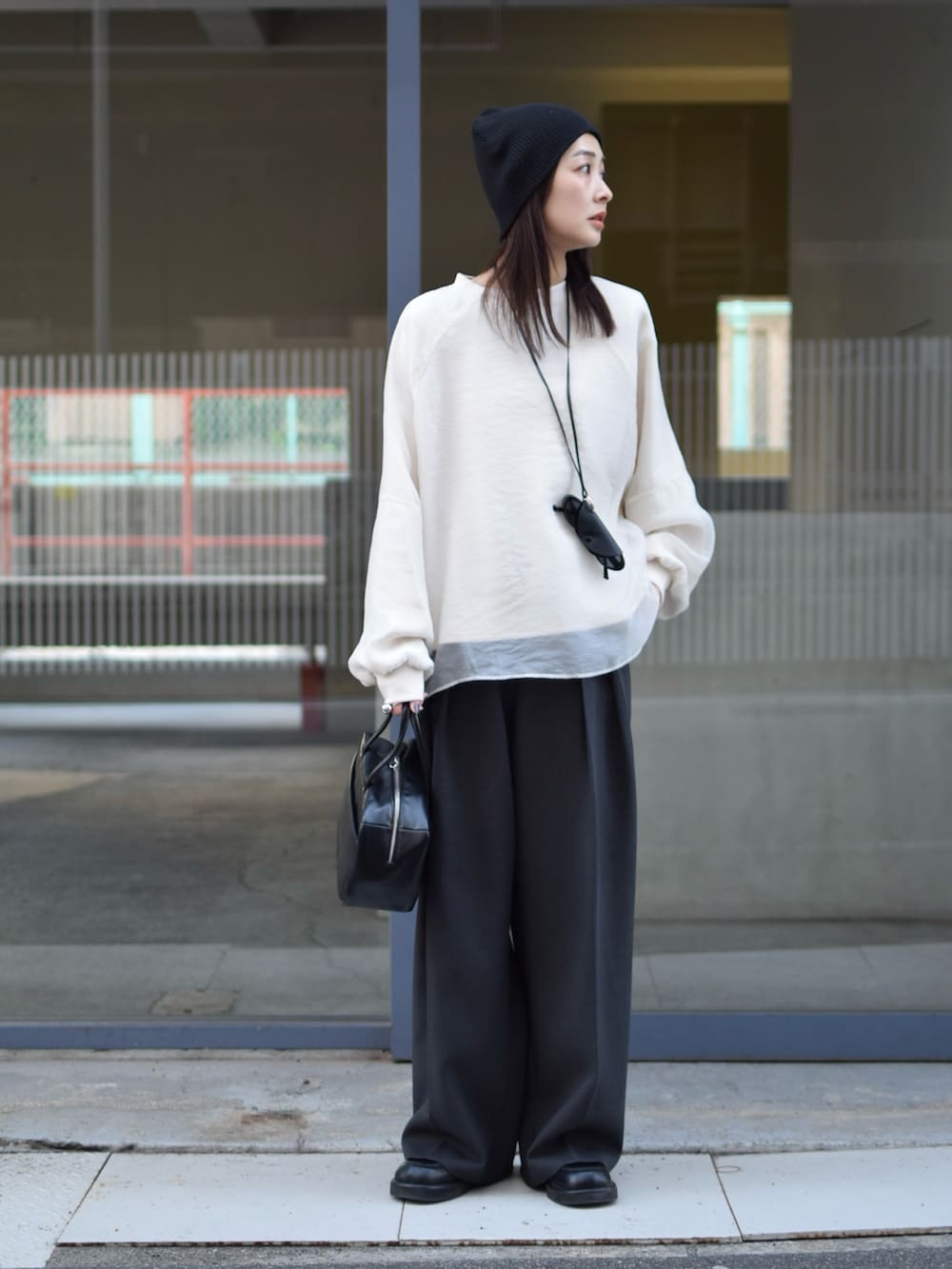 ホワイト系のTシャツ/カットソー、グレー系のその他パンツ、ブラック系のボストンバッグを着用したレディースの冬コーディネートの2枚目の写真