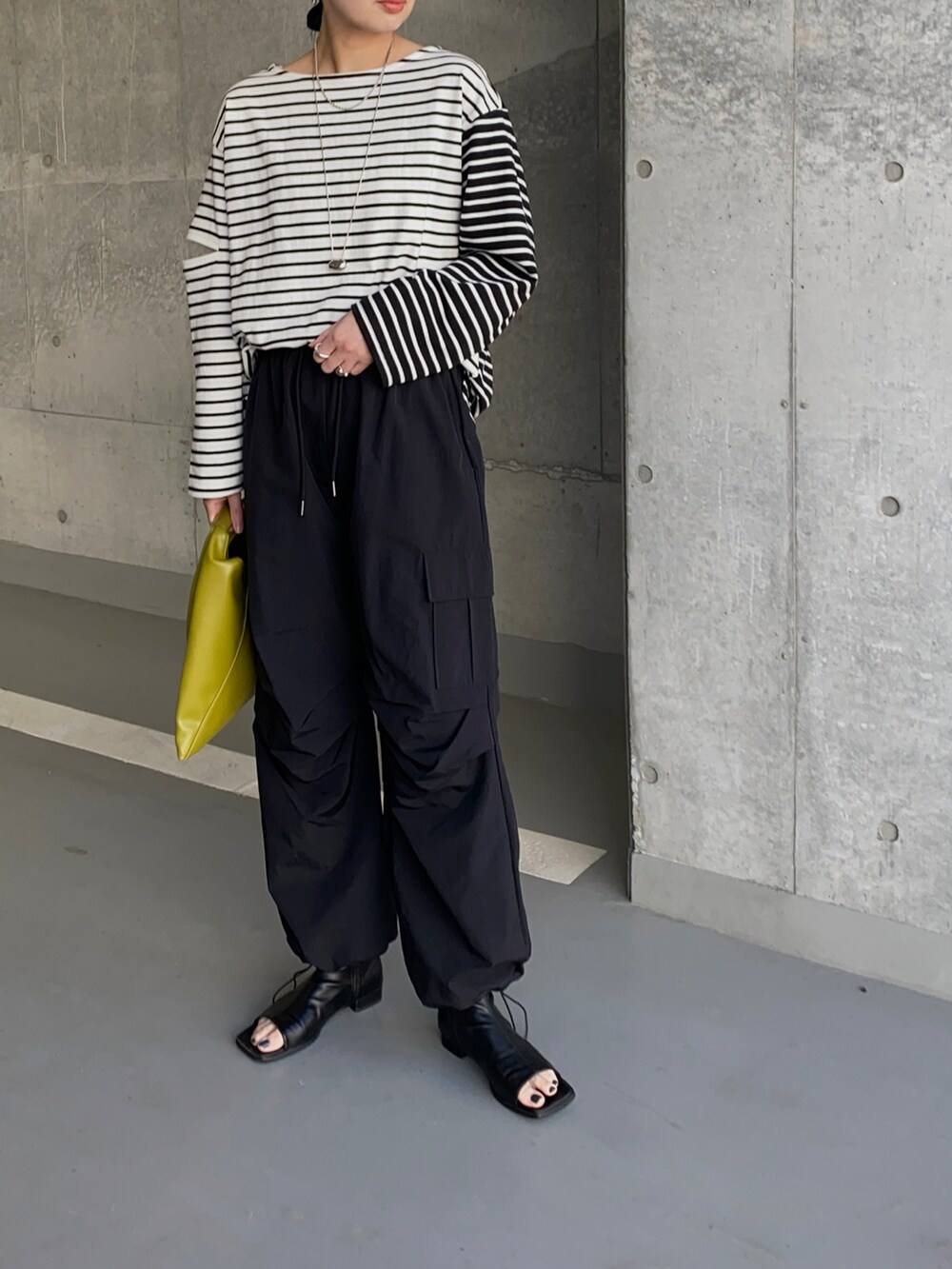 ブラック系のTシャツ/カットソー、ブラック系のその他パンツ、イエロー系のハンドバッグを着用したレディースの春コーディネートの3枚目の写真