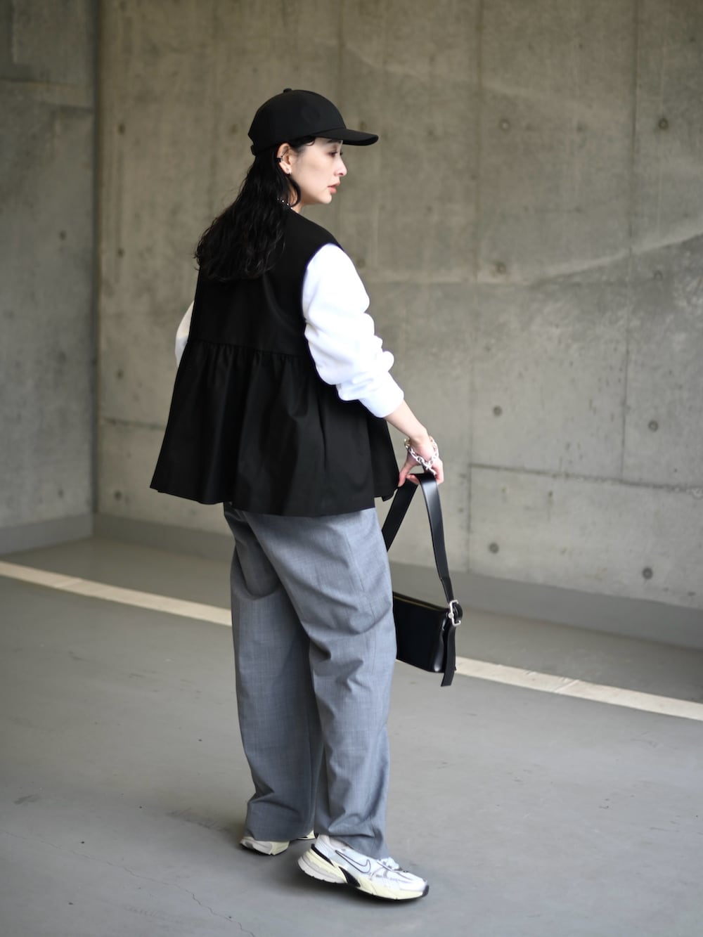 ブラック系のその他アウター、グレー系のスラックス、ホワイト系のスニーカーを着用したレディースの冬コーディネートの4枚目の写真