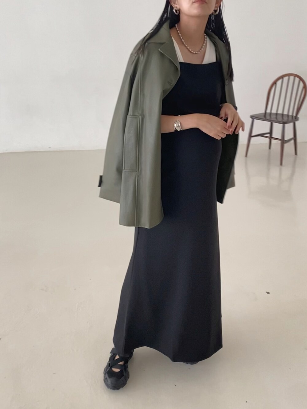 ブラック系のワンピース、グリーン系のその他アウター、シルバー系のネックレスを着用したレディースの秋コーディネートの2枚目の写真