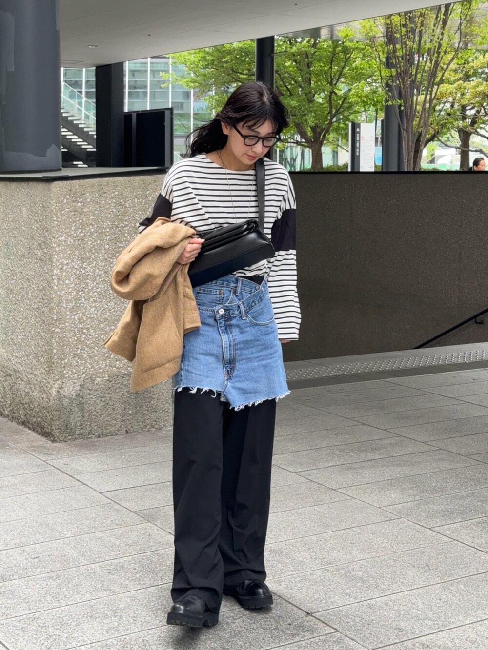 ブラック系のTシャツ/カットソー、ブラック系のスラックス、ブラック系のブーツを着用したレディースの春コーディネートの2枚目の写真