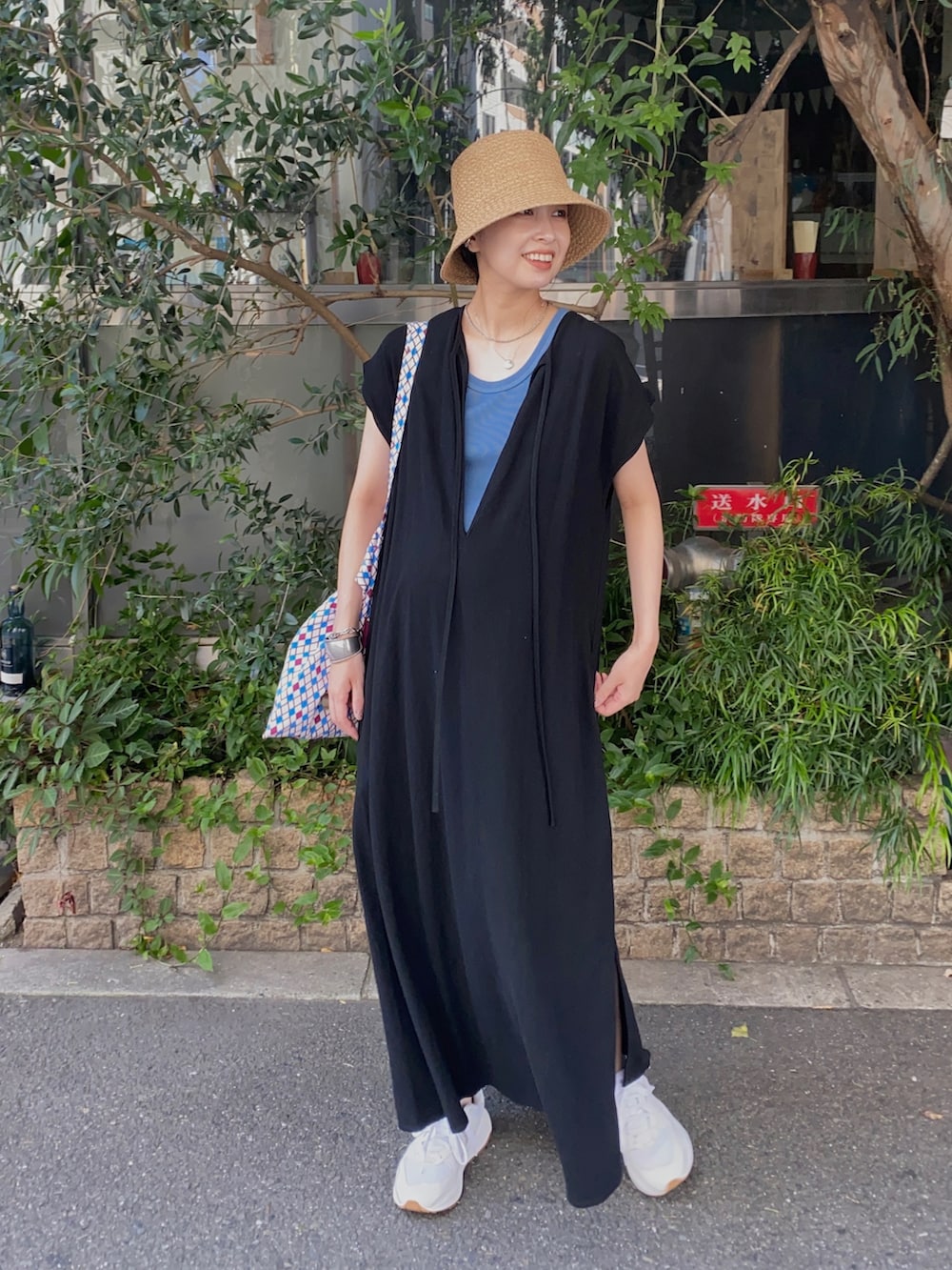 ブラック系のワンピース、ホワイト系のスニーカー、ブルー系のタンクトップを着用したレディースの秋コーディネートの2枚目の写真