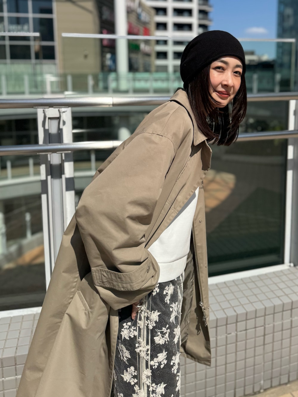 ブラック系のスウェットパンツ、ベージュ系のステンカラーコート、ブラック系のニットキャップ/ビーニーを着用したレディースの春コーディネートの5枚目の写真