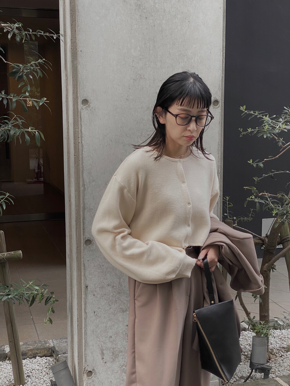 ホワイト系のカーディガン/ボレロ、ブラック系のショルダーバッグ、ブラック系のブーツを着用したレディースの秋コーディネートの2枚目の写真