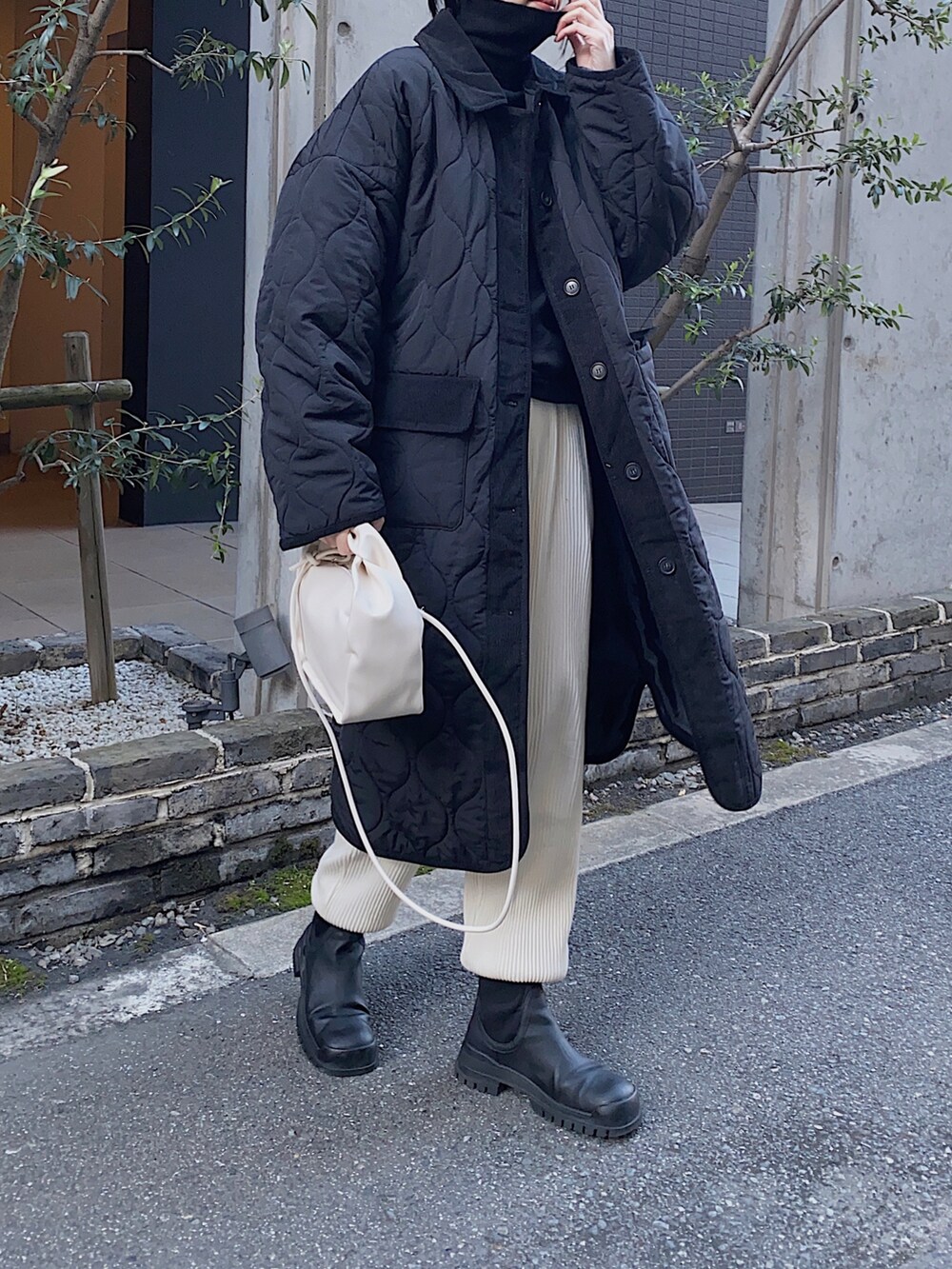 ブラック系のジャケット/アウター、ブラック系のニット/セーター、ホワイト系のその他パンツを着用したレディースの冬コーディネートの2枚目の写真