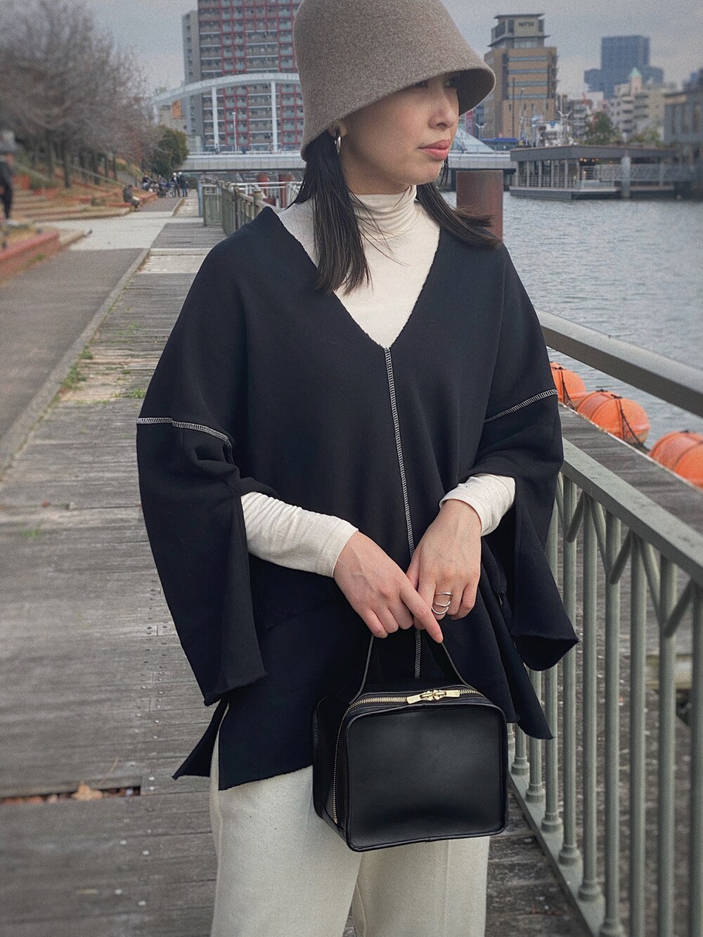 ブラック系のスウェット、ホワイト系のその他パンツ、ベージュ系の帽子を着用したレディースの冬コーディネートの3枚目の写真