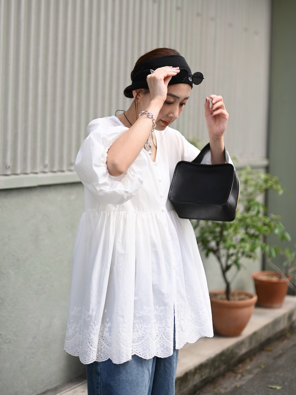 ホワイト系のシャツ/ブラウス、ブルー系のデニムパンツ、ブラック系のバレエシューズを着用したレディースの夏コーディネートの3枚目の写真