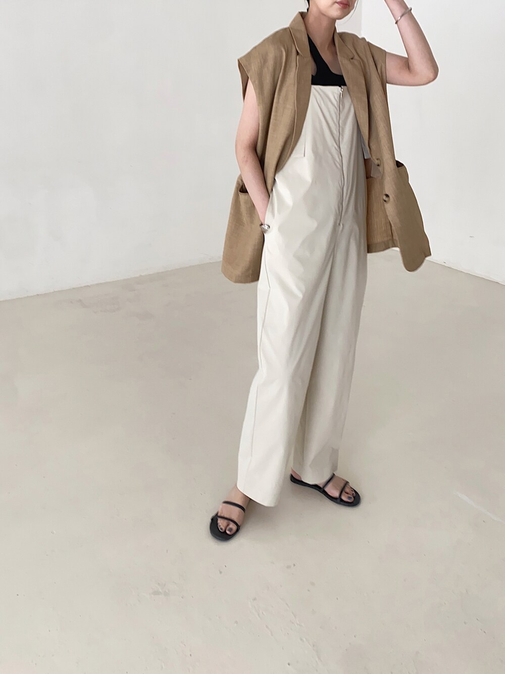 ホワイト系のサロペット/オーバーオール、ブラック系のサンダル、ブラック系のニット/セーターを着用したレディースの夏コーディネートの2枚目の写真