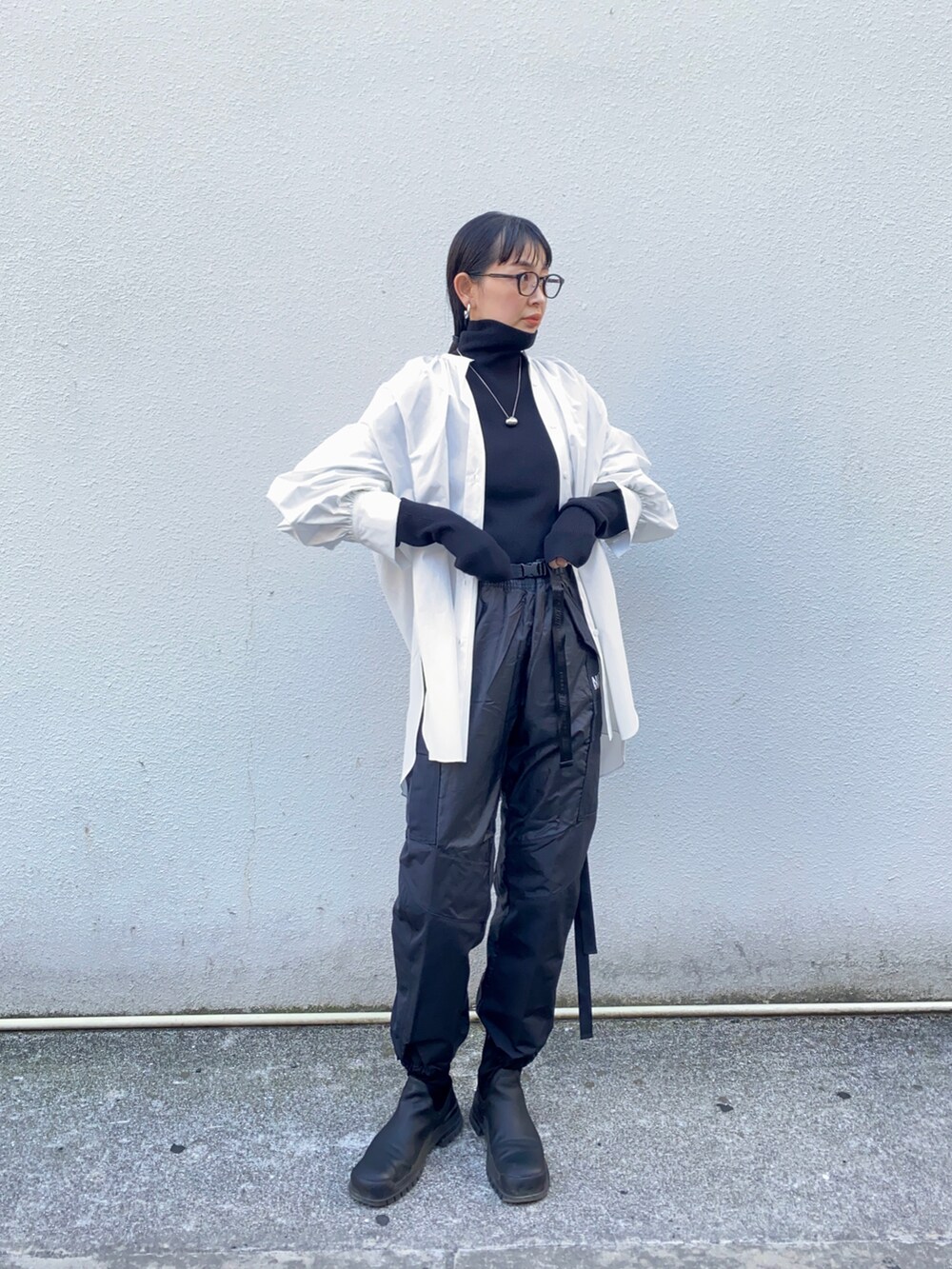 ホワイト系のシャツ/ブラウス、ブラック系のニット/セーター、ブラック系のパンツを着用したレディースの冬コーディネートの3枚目の写真