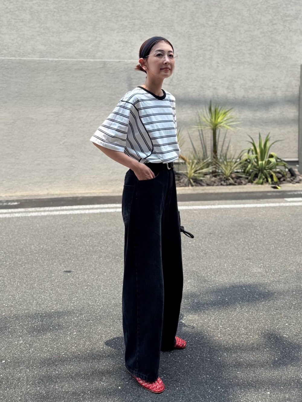 ブラック系のデニムパンツ、ホワイト系のTシャツ/カットソー、ブラック系のヘアバンドを着用したレディースの夏コーディネートの4枚目の写真