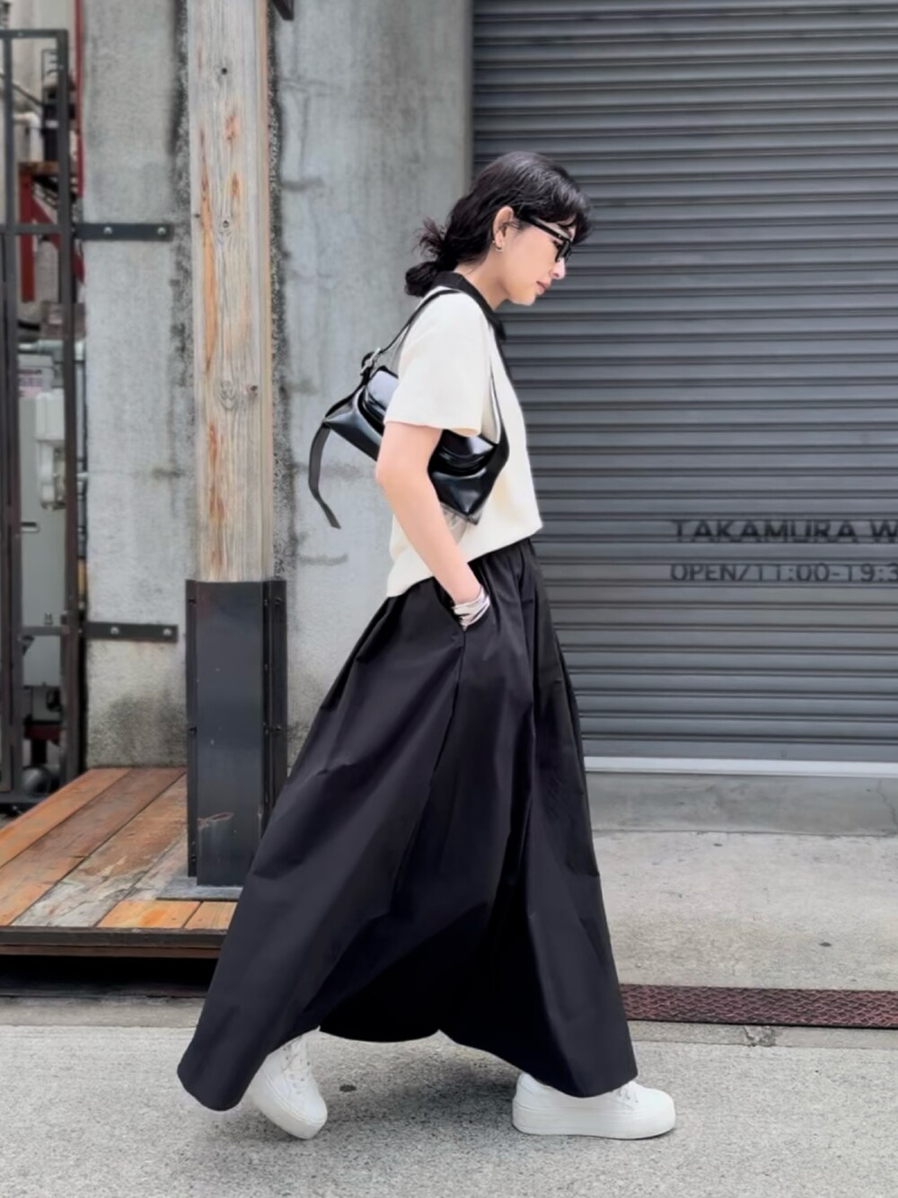 ホワイト系のTシャツ/カットソー、ブラック系のスカート、ホワイト系のスニーカーを着用したレディースの春コーディネートの4枚目の写真