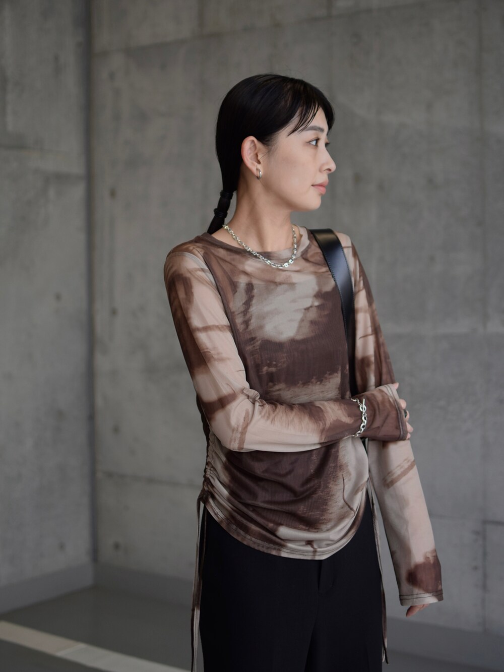 ブラウン系のTシャツ/カットソー、ブラック系のその他パンツ、ブラック系のショルダーバッグを着用したレディースの秋コーディネートの4枚目の写真