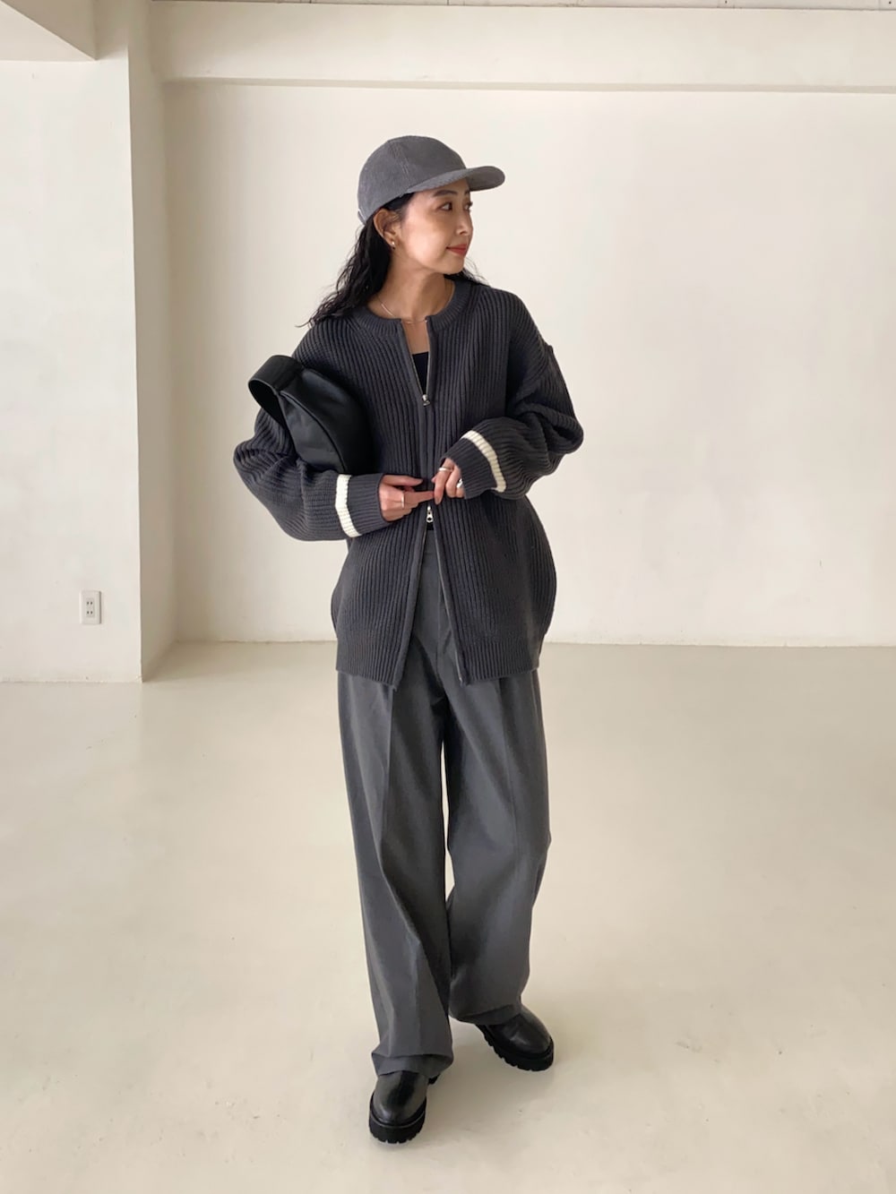 グレー系のカーディガン/ボレロ、グレー系のスラックス、ブラック系のブーツを着用したレディースの冬コーディネートの3枚目の写真