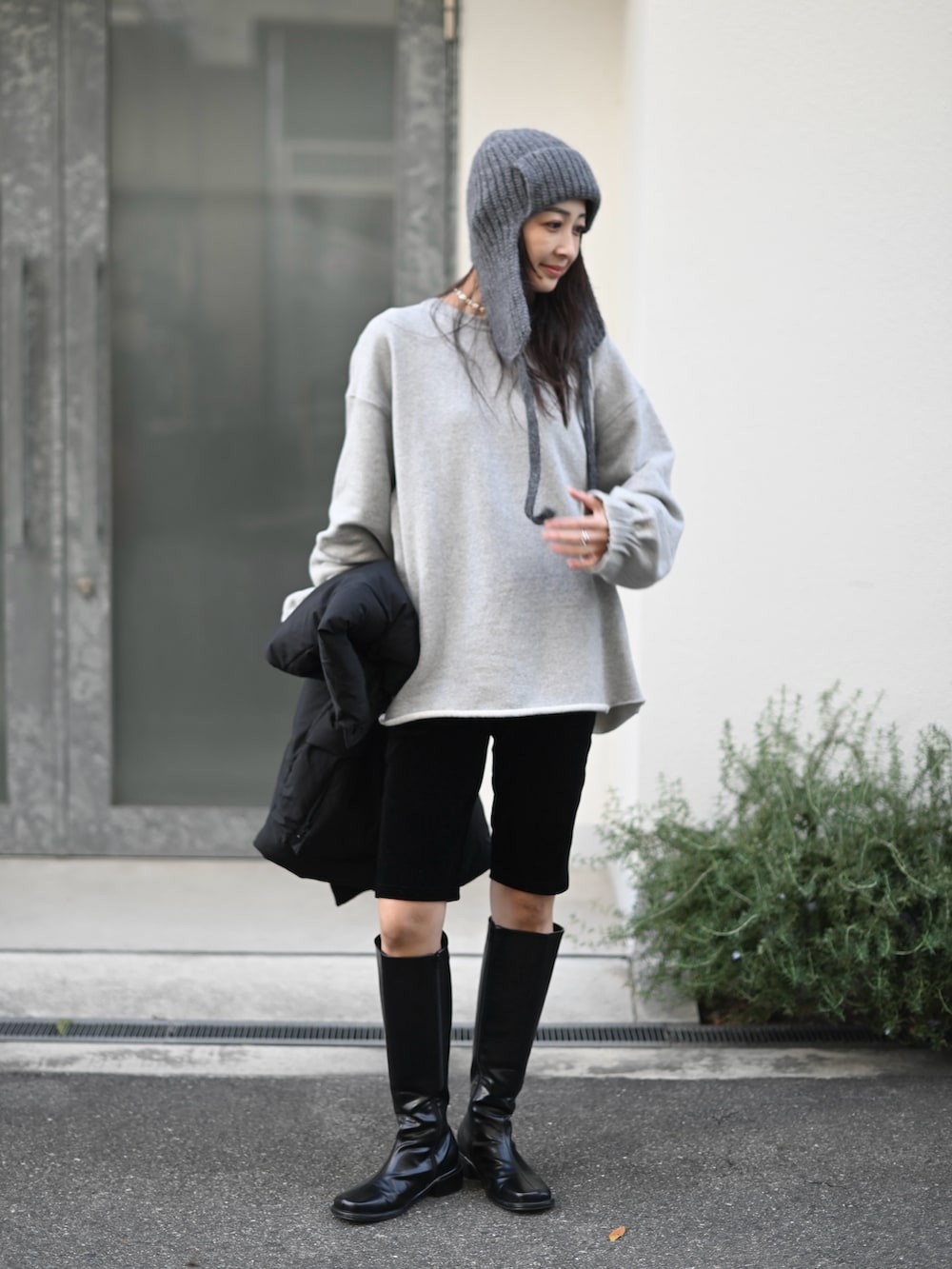 ブラック系のその他アウター、ブラック系のその他パンツ、グレー系のスウェットを着用したレディースの冬コーディネートの4枚目の写真