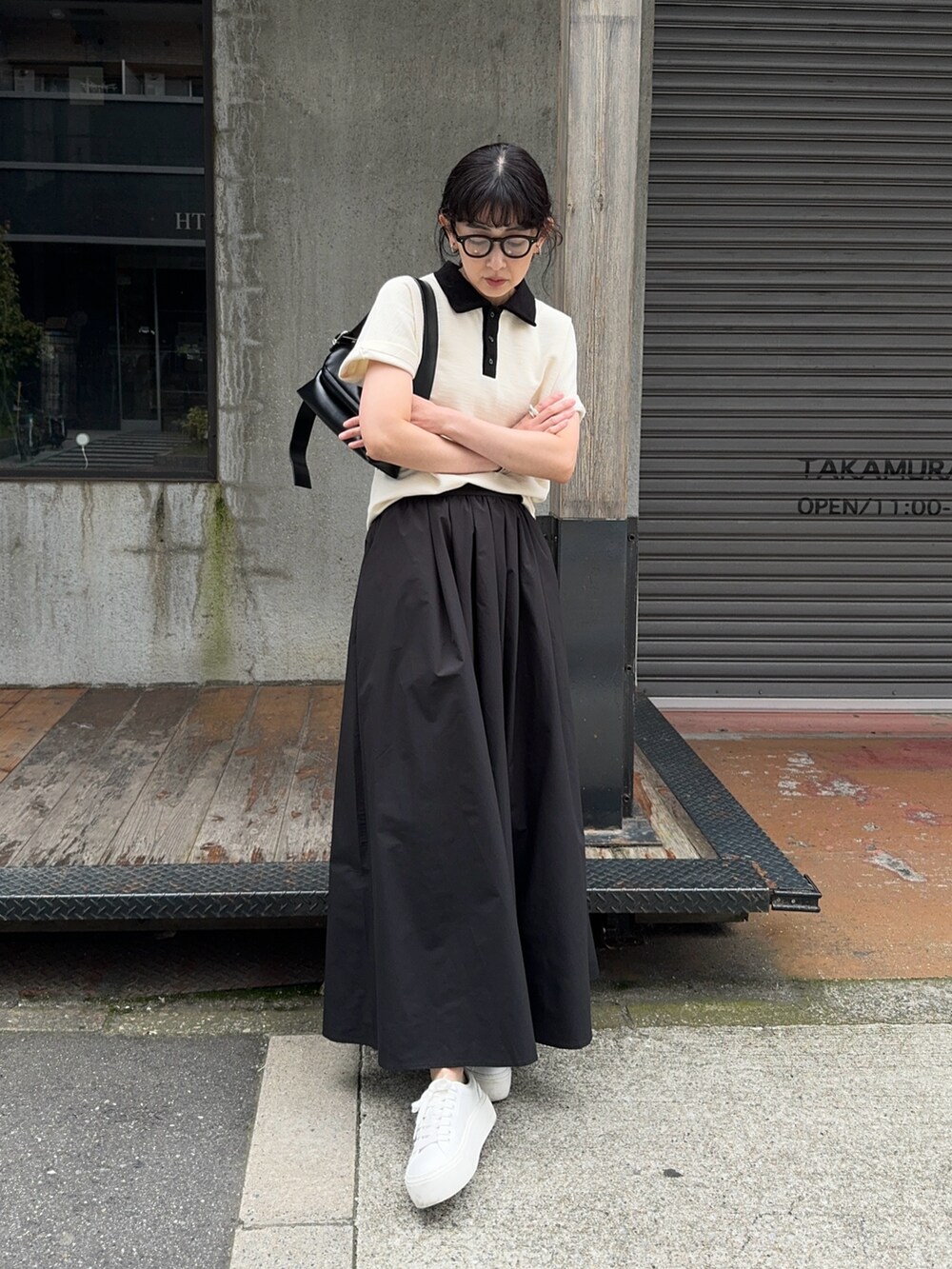 ホワイト系のTシャツ/カットソー、ブラック系のスカート、ホワイト系のスニーカーを着用したレディースの春コーディネートの3枚目の写真