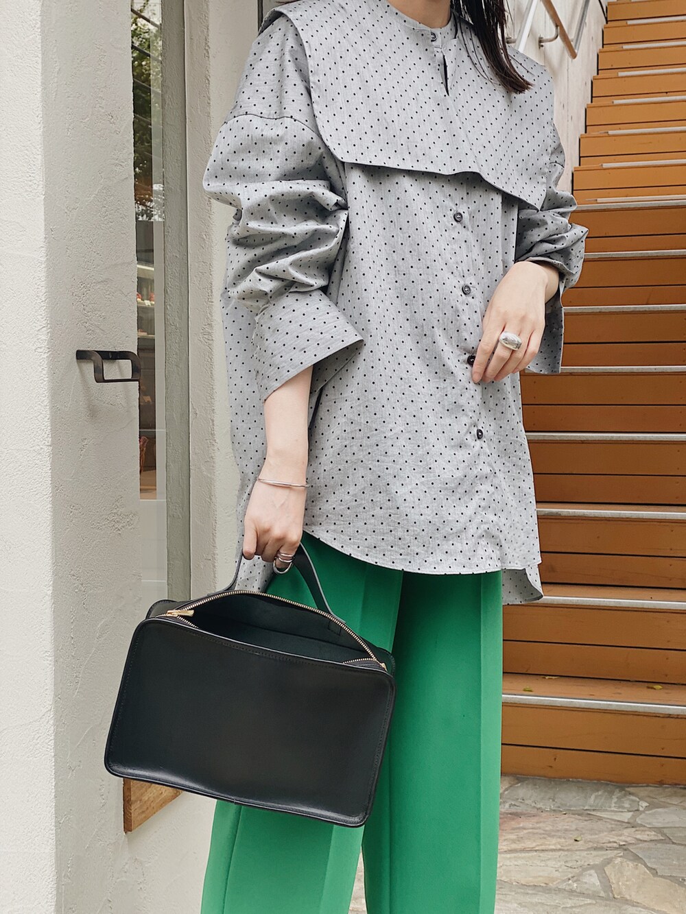 ブラック系のシャツ/ブラウス、ブラック系のハンドバッグ、グリーン系のその他パンツを着用したレディースの春コーディネートの2枚目の写真