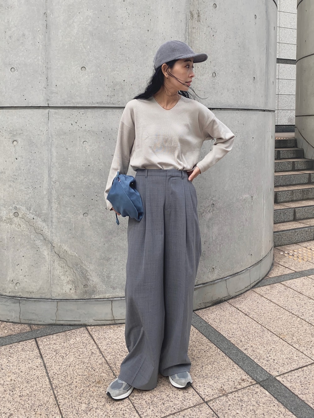 グレー系のニット/セーター、グレー系のスラックス、グレー系のスニーカーを着用したレディースの秋コーディネートの3枚目の写真