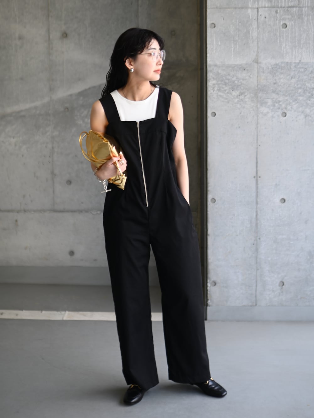 ブラック系のサロペット/オーバーオール、ゴールド系のショルダーバッグ、ブラック系のローファーを着用したレディースの春コーディネートの3枚目の写真