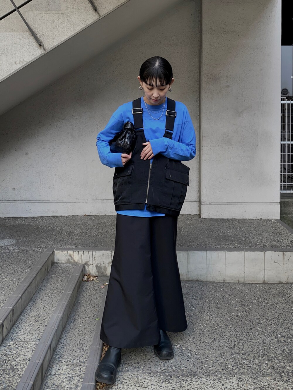 ブラック系のベスト、ブラック系のスカートを着用したレディースの春コーディネートの3枚目の写真
