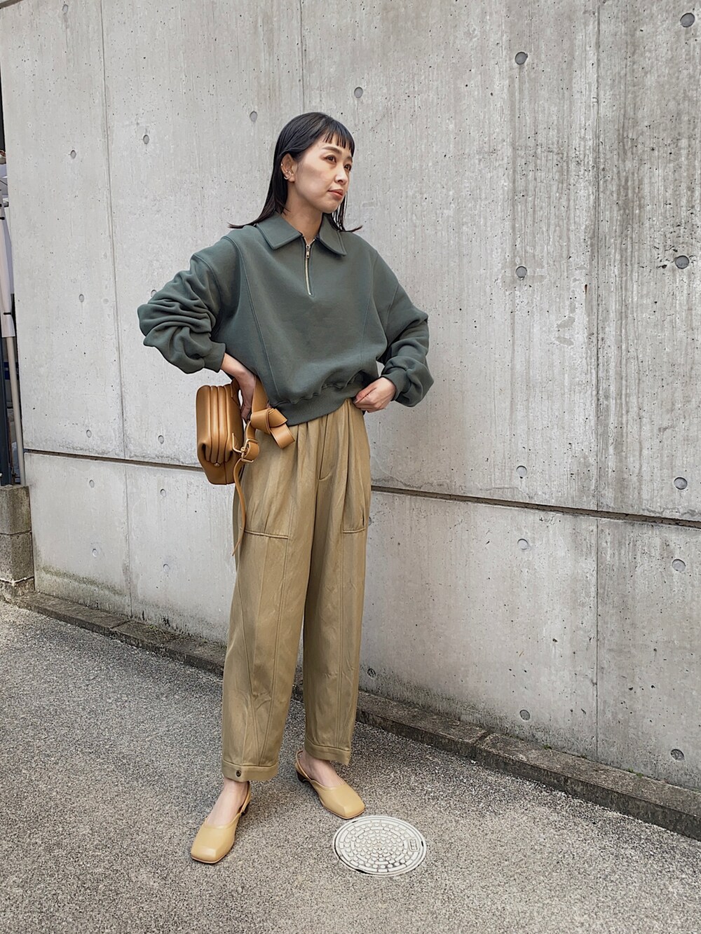 グリーン系のスウェット、ブラウン系のショルダーバッグ、グリーン系のその他パンツを着用したレディースの冬コーディネートの3枚目の写真