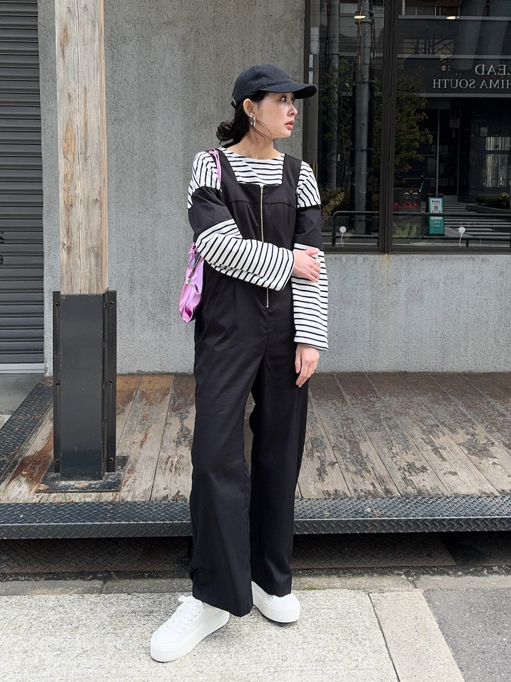 ブラック系のサロペット/オーバーオール、ホワイト系のスニーカー、ブラック系のTシャツ/カットソーを着用したレディースの春コーディネートの3枚目の写真