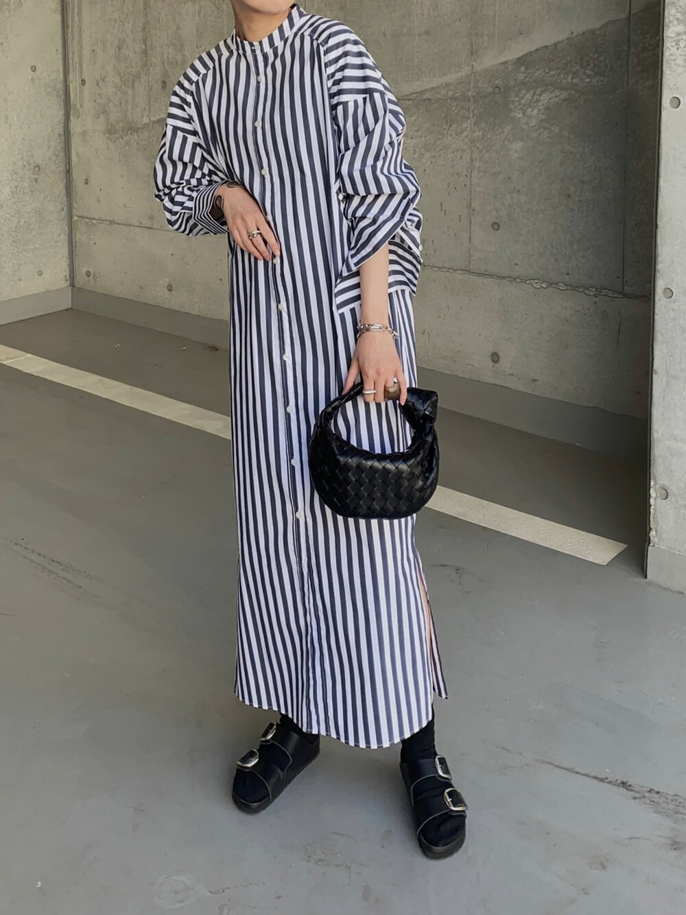 ホワイト系のシャツワンピース、ブラック系のサンダル、シルバー系のリングを着用したレディースの春コーディネートの4枚目の写真
