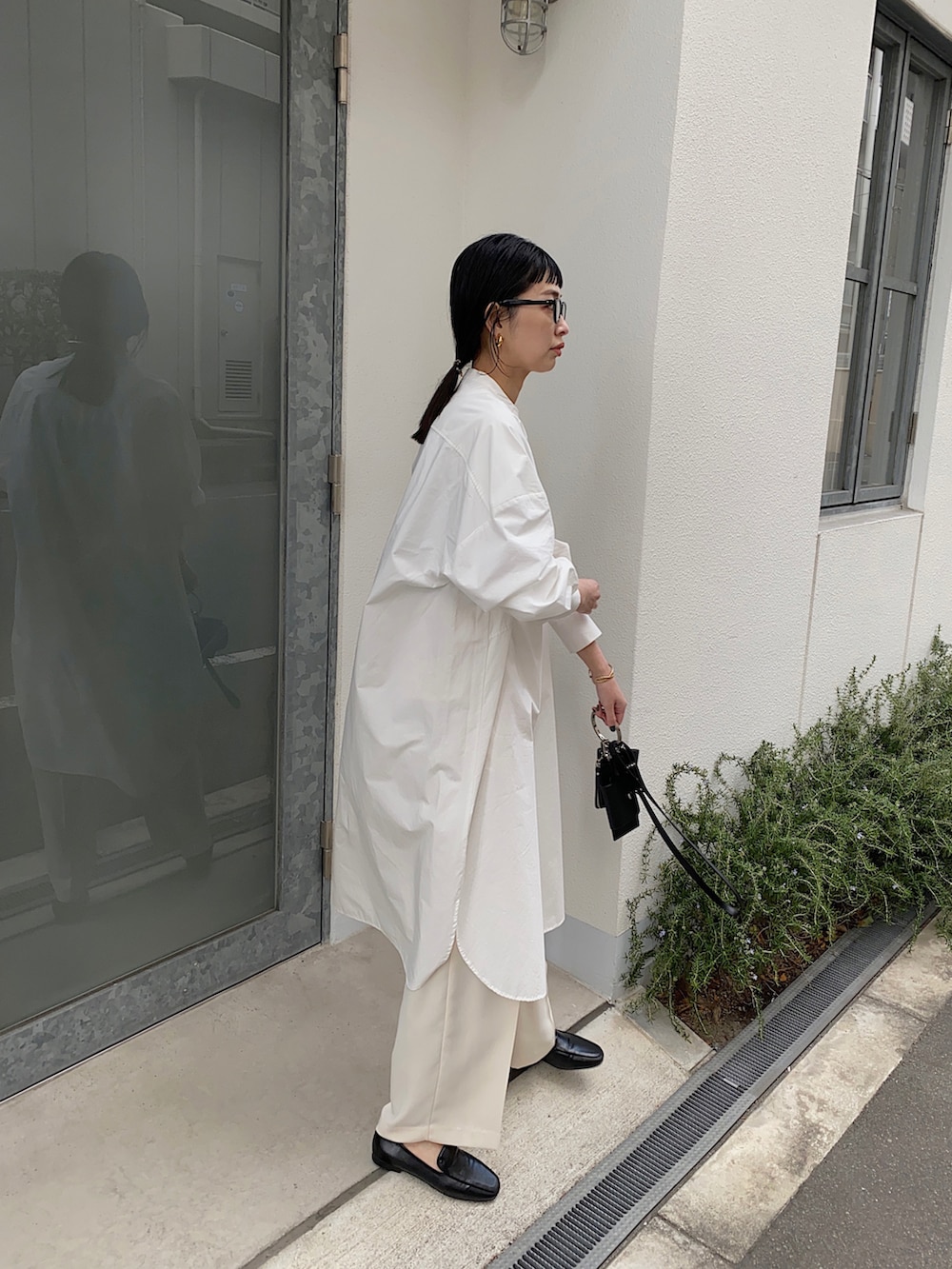 ホワイト系のシャツワンピース、ブラック系のショルダーバッグ、ブラック系のローファーを着用したレディースの冬コーディネートの2枚目の写真