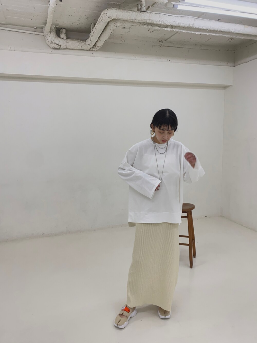 ホワイト系のスカート、その他のスニーカー、シルバー系のネックレスを着用したレディースの春コーディネートの3枚目の写真