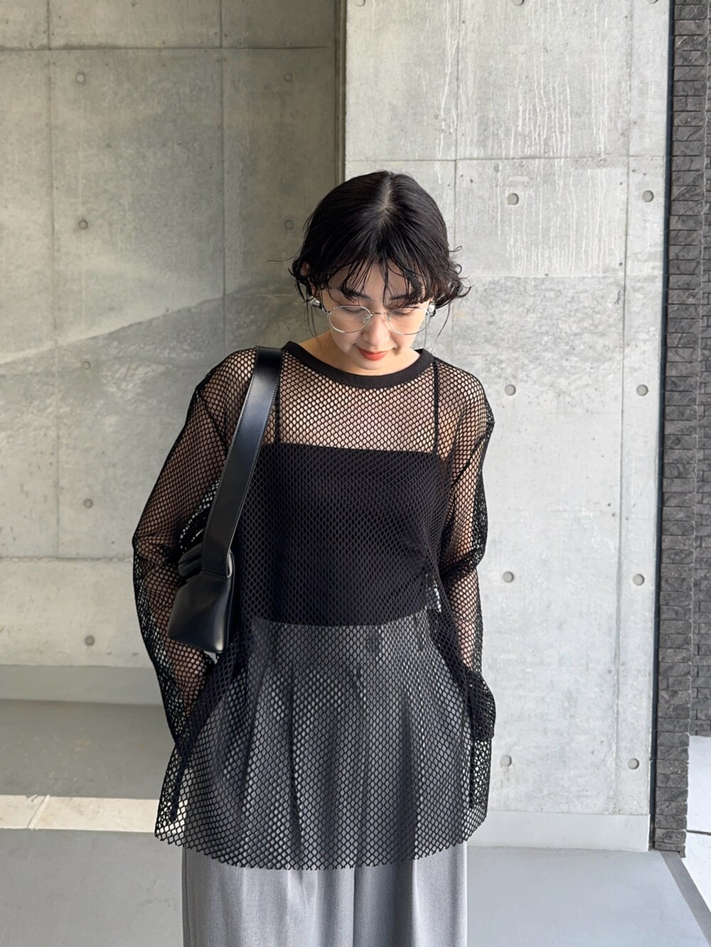 ブラック系のTシャツ/カットソー、ブラック系のショルダーバッグ、グレー系のスラックスを着用したレディースの夏コーディネートの2枚目の写真